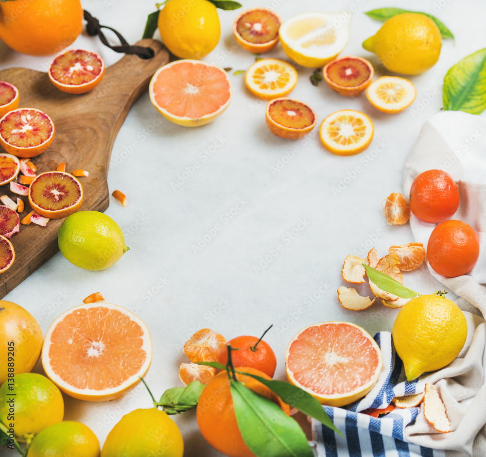 天然新鲜柑橘类水果片，放在灰色大理石餐桌背景上的乡村木板上。