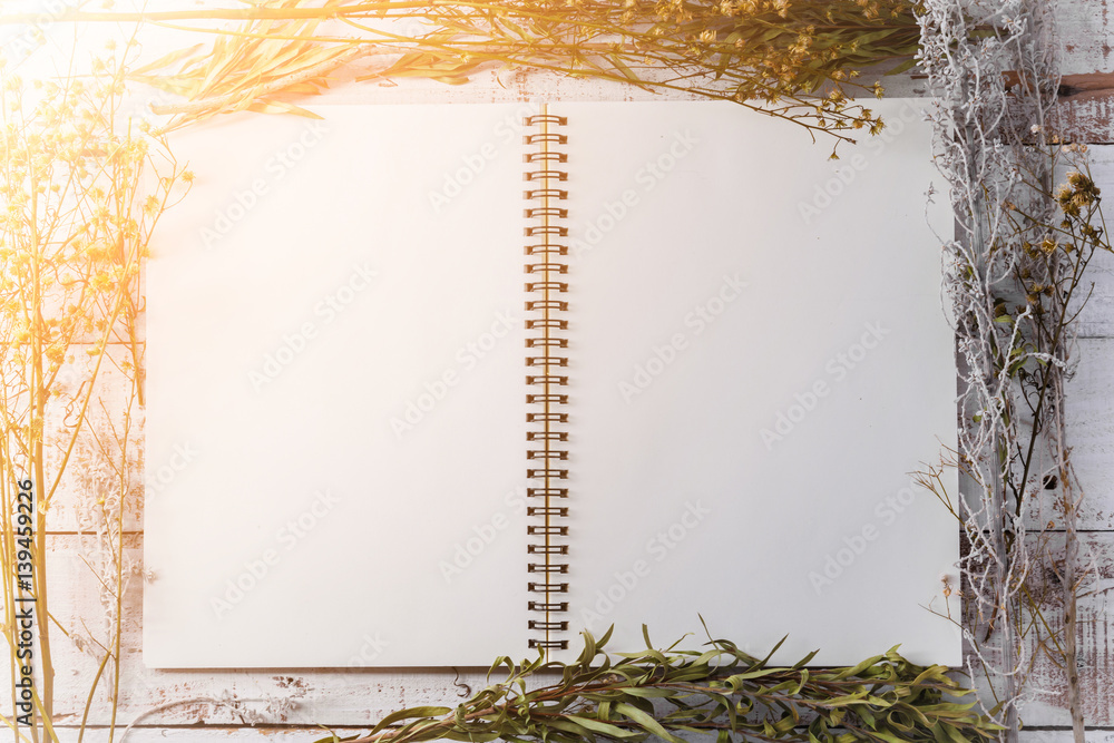 blank notebook on old vintage with dry flower on wooden background with free copyspace for your text
