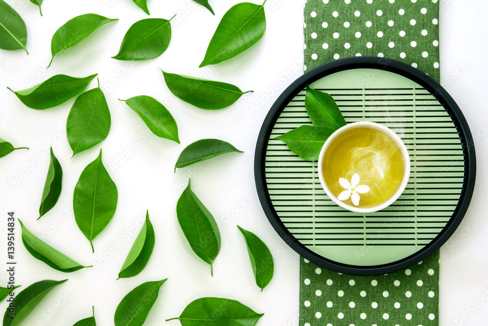 一杯热茶的俯视图，白底绿叶装饰，有机绿Te