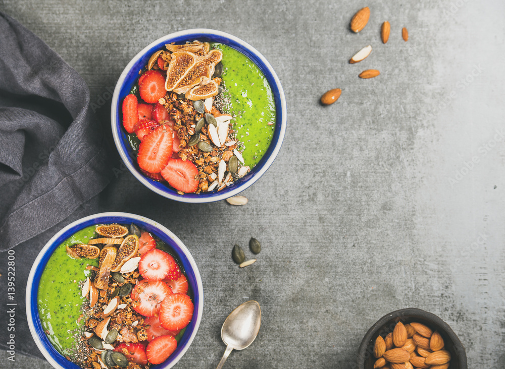 Healthy breakfast. Green smoothie bowls with strawberries, granola, chia and pumpkin seeds, dried fi