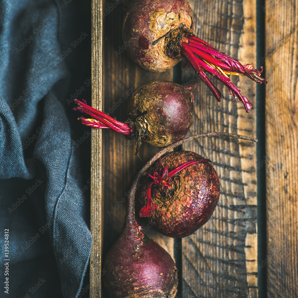 Raw organic purple beetroots in wooden box, selective fovus, top view, square crop