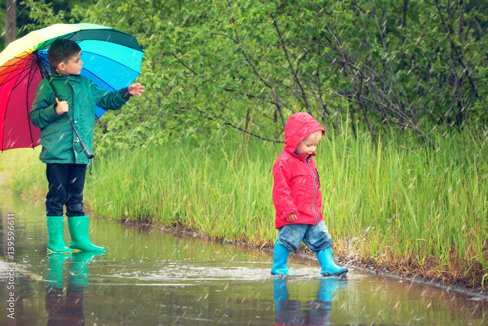 雨天，孩子们穿着雨鞋在水坑里行走