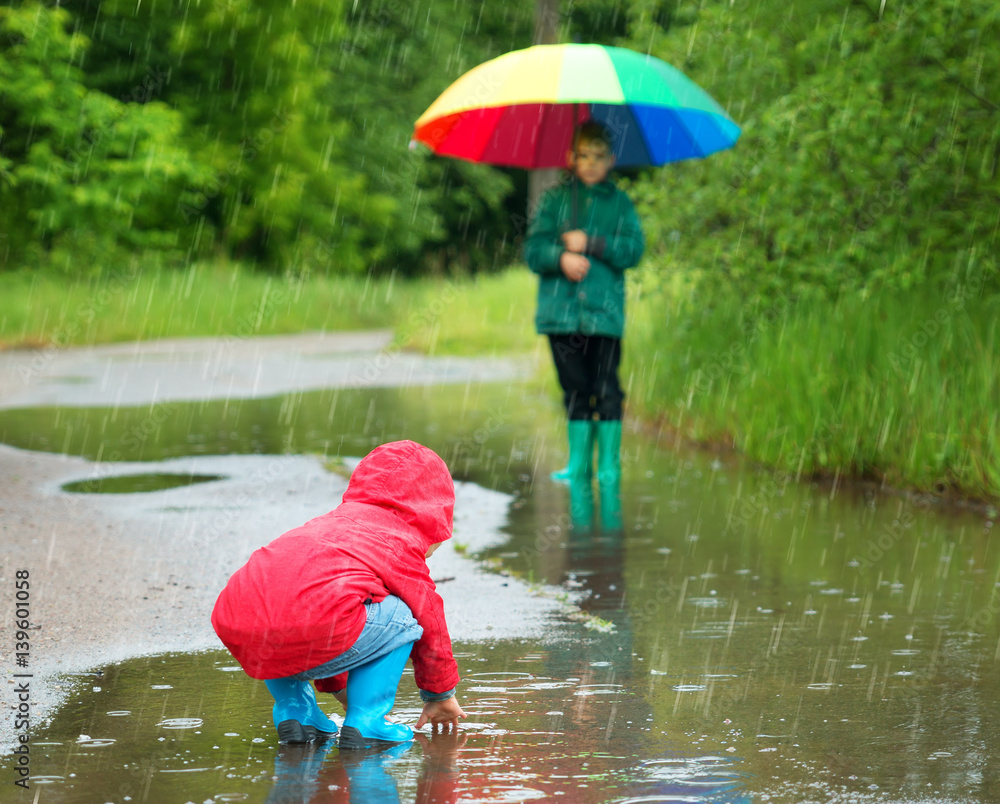 雨天，孩子们穿着雨鞋在水坑里行走