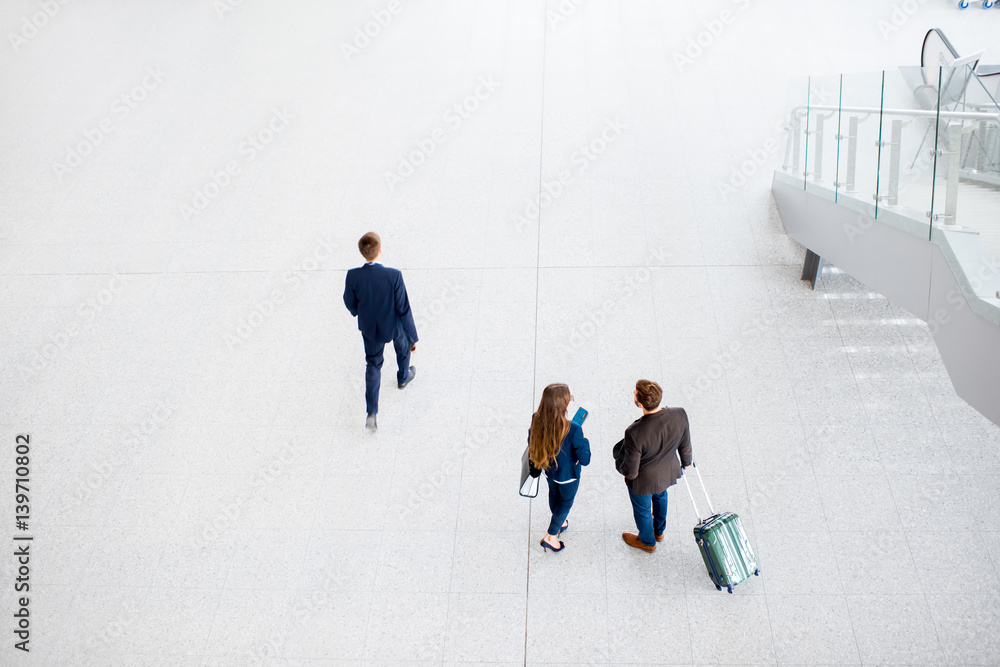 Business couple walking with baggage at the airport. Top, wide angle view with copy space