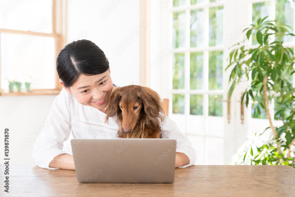 young asian woman with dog using laptop computer