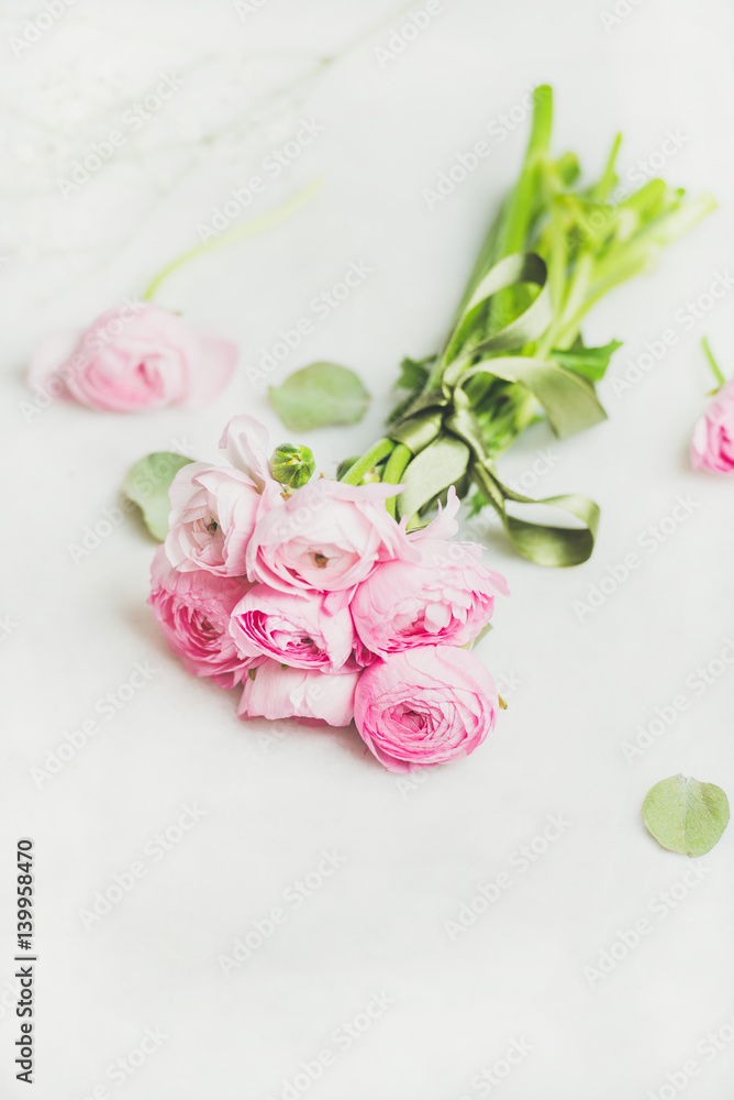 Light pink spring ranunkulus flowers on white marble background, selective focus, copy space. Spring