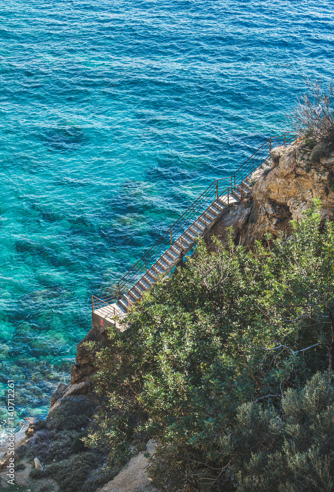 岩石上的楼梯通往图尔地中海南海岸的泻湖和绿松石海水