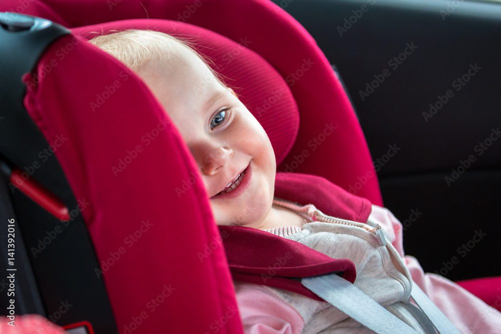 小女孩坐在汽车安全座椅上
