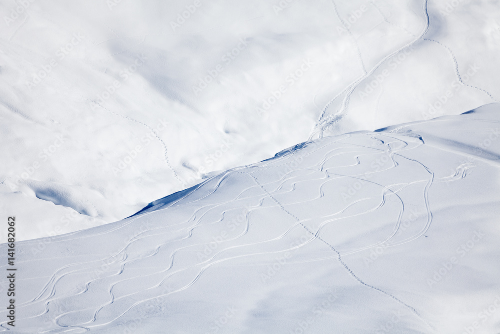 雪山被弯曲的滑雪痕迹所笼罩