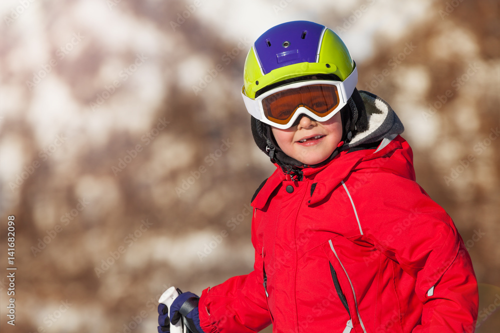 Portrait of little skier in safety helmet and mask