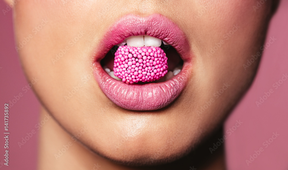 美丽的粉红色嘴唇配一块糖果