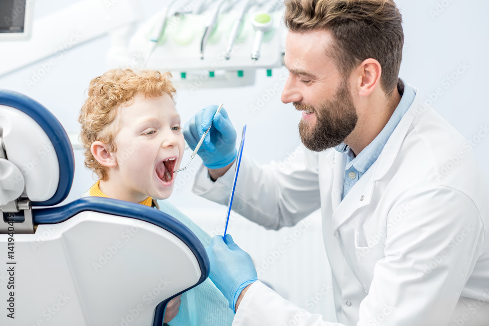 儿童牙医在牙科诊所检查小男孩