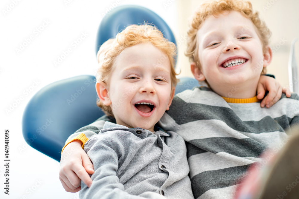 一个快乐的年轻兄弟坐在牙科诊所的牙科椅上的肖像