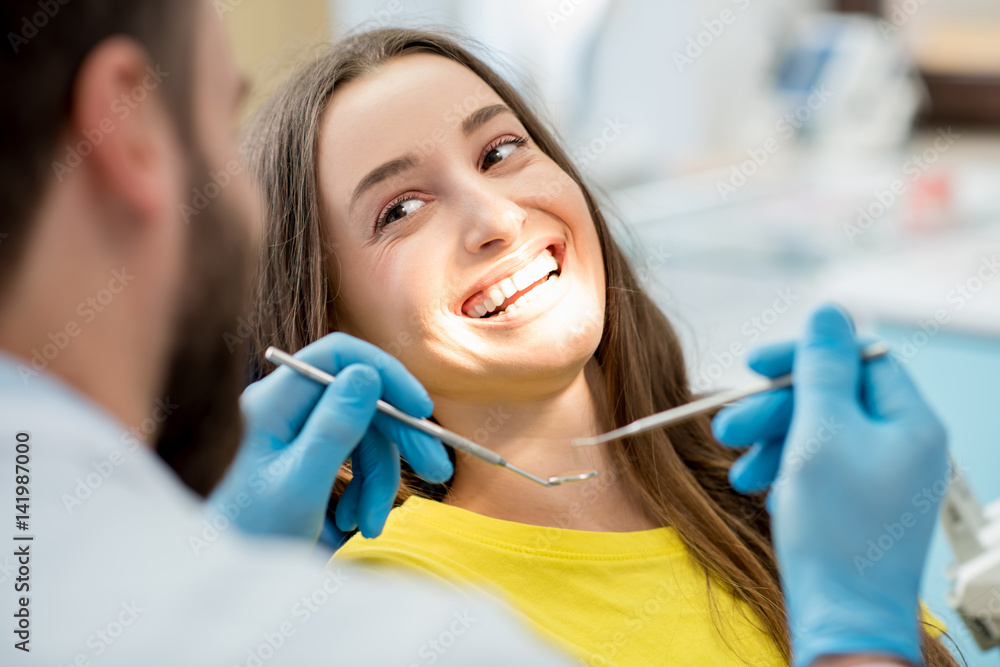 一位面带笑容的女士坐在牙科诊所检查时的肖像