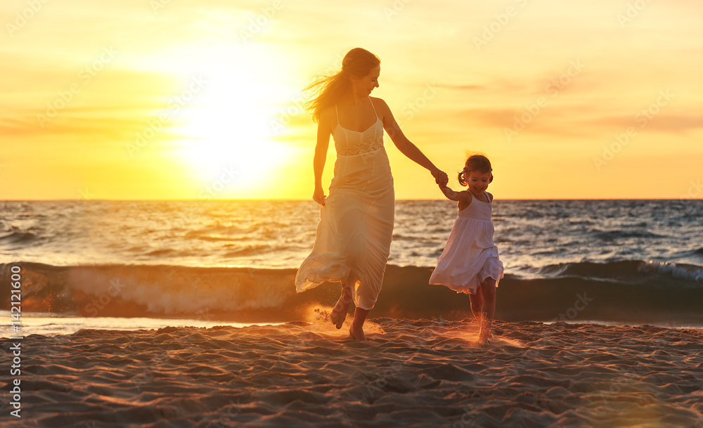 幸福家庭母女在海滩上奔跑、欢笑和玩耍