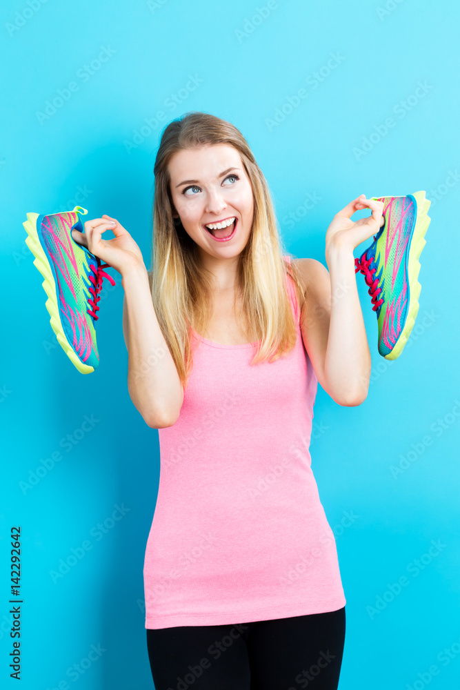快乐的年轻女人拿着鞋子