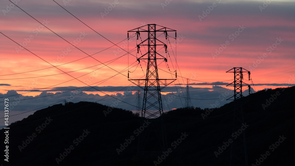海洋山脉上的日落剪影电力线塔的形状