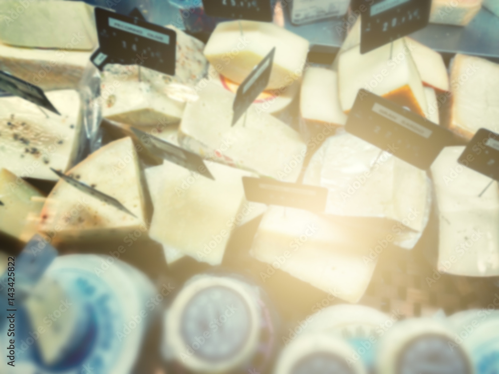 Selection of French and Italian cheese in farmers shop. Blurry food background