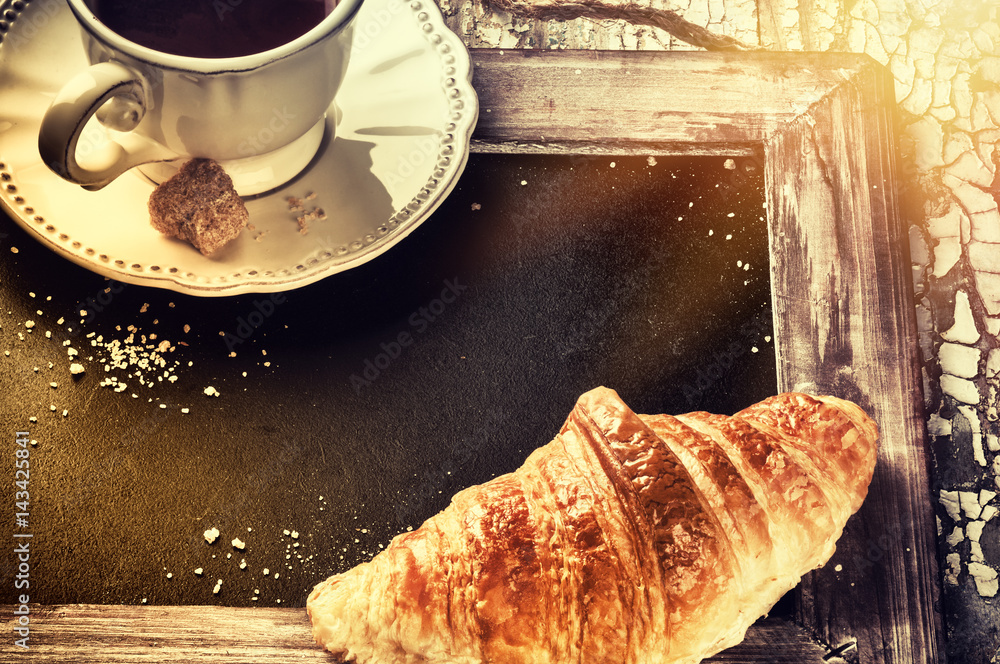Breakfast setting with coffee cup and croissant. Menu concept background