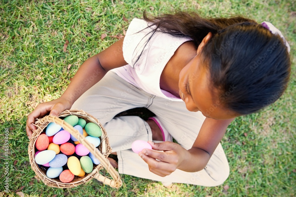 坐在草地上数复活节彩蛋的小女孩