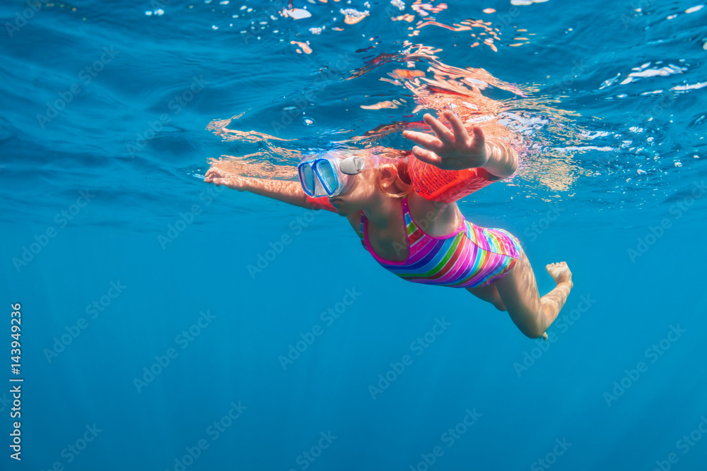 快乐的浮潜女婴戴着口罩在水下游泳，在游泳池里玩得很开心。健康的生活方式，人们w