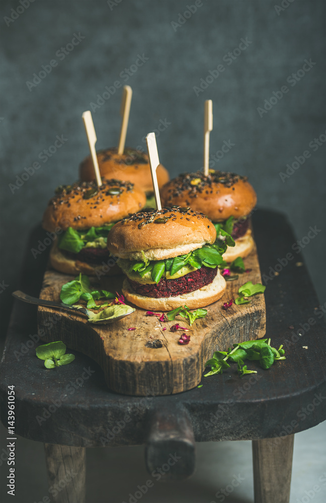 Healthy vegan burger with beetroot and quinoa patty, arugula, avocado sauce, wholegrain buns on rust