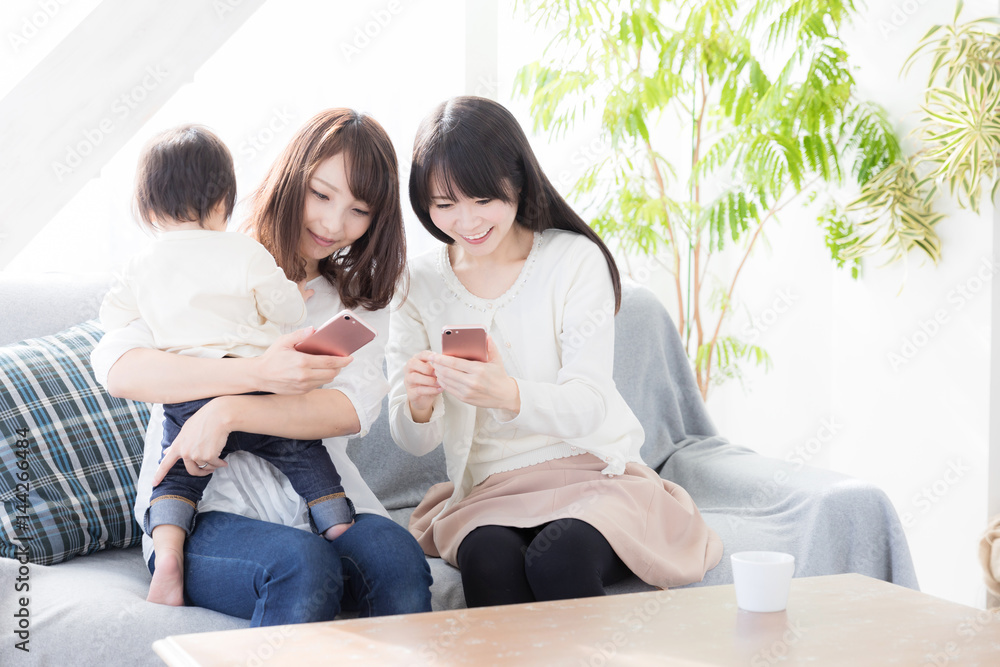 亚洲年轻家庭在客厅使用智能手机
