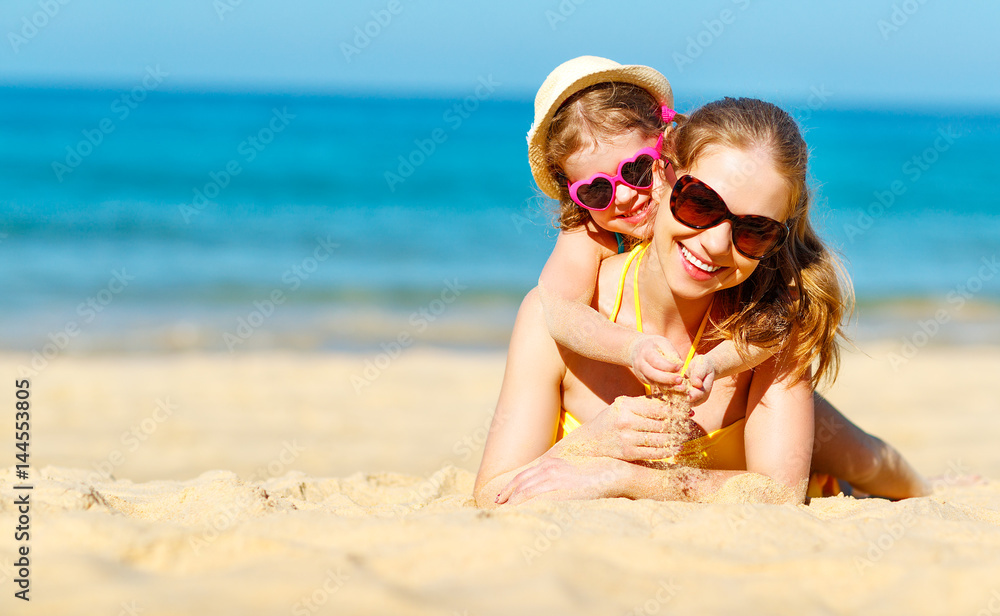 快乐的家庭母亲和孩子女儿在夏天的海滩上