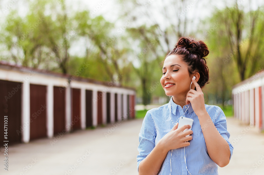 Beautiful girl with earphones walking outdoors