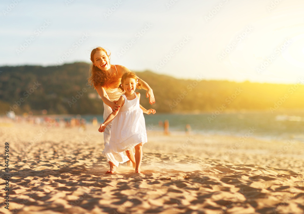 幸福家庭母女在海滩上奔跑、欢笑、玩耍