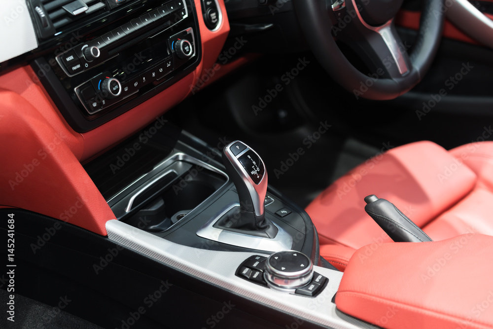 红色豪华车内饰，带方向盘、换档杆、空调和收音机按钮控制