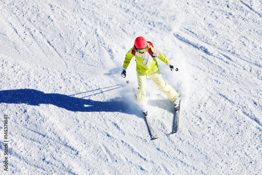 Sporty woman skiing downhill in high mountains