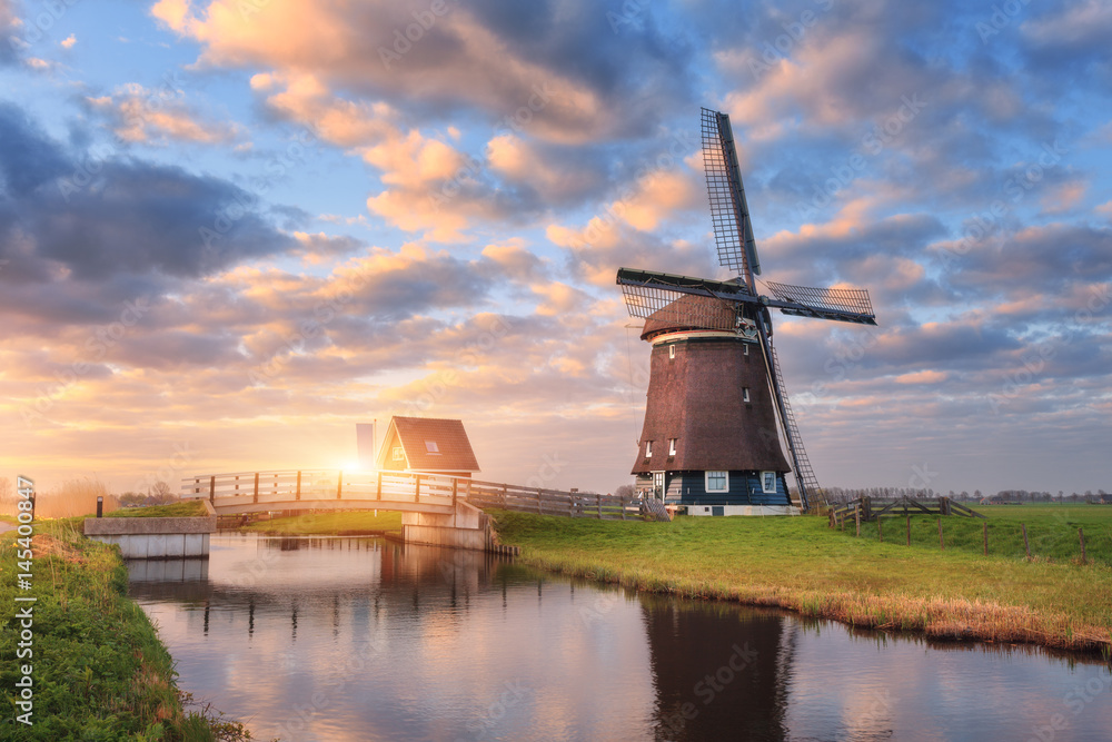 荷兰日出时运河附近的风车。美丽的古老荷兰风车和五颜六色的s