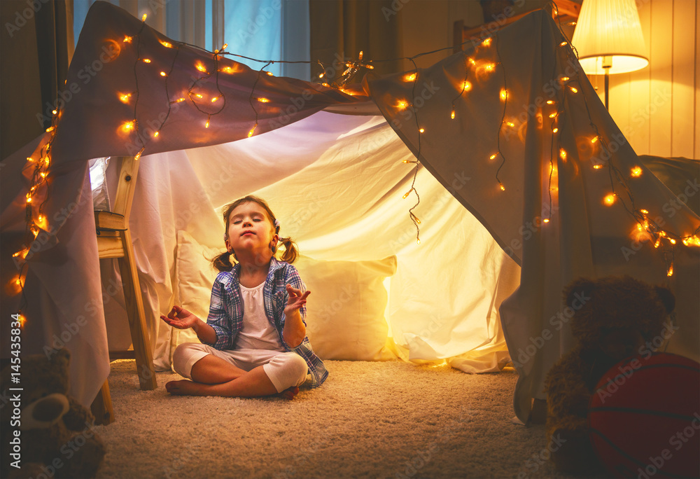 家里帐篷里玩瑜伽的小女孩冥想