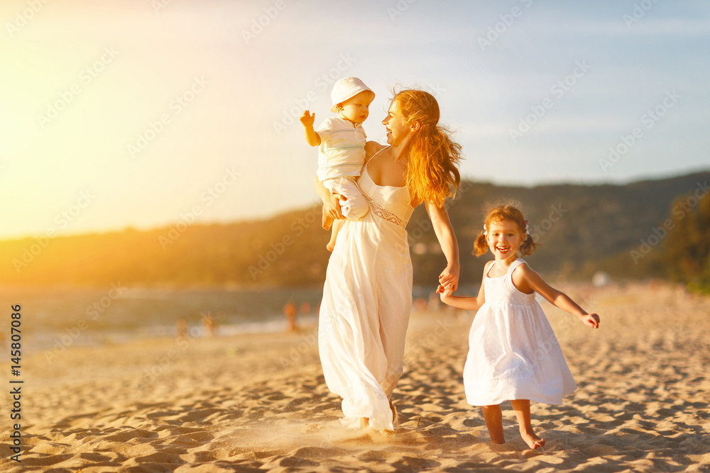 快乐的家庭母亲和孩子在夏天的海边海滩上