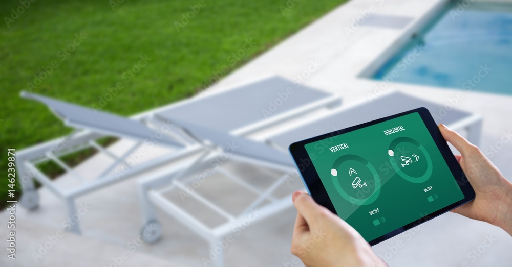 Hands using smart home application on digital tablet at poolside