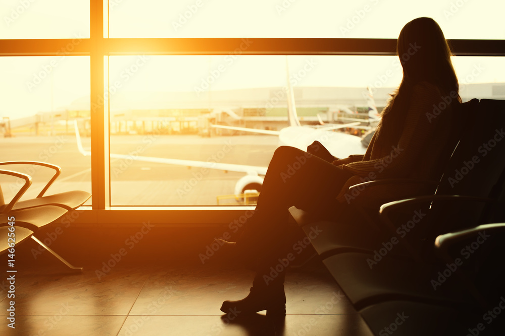 一位年轻女性旅客在机场等待出发的剪影