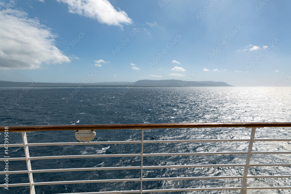 从游轮上层甲板俯瞰阳光明媚的海洋，乘船度假