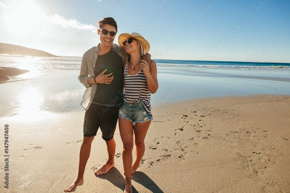 浪漫的年轻情侣在海滩上漫步