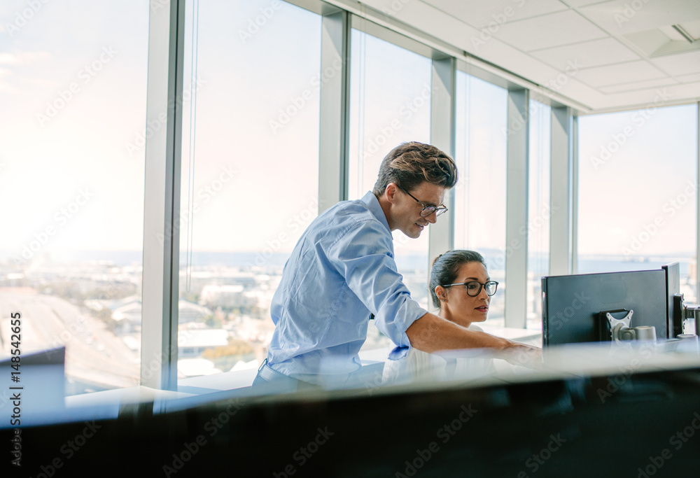 Coworkers working together computer in modern office