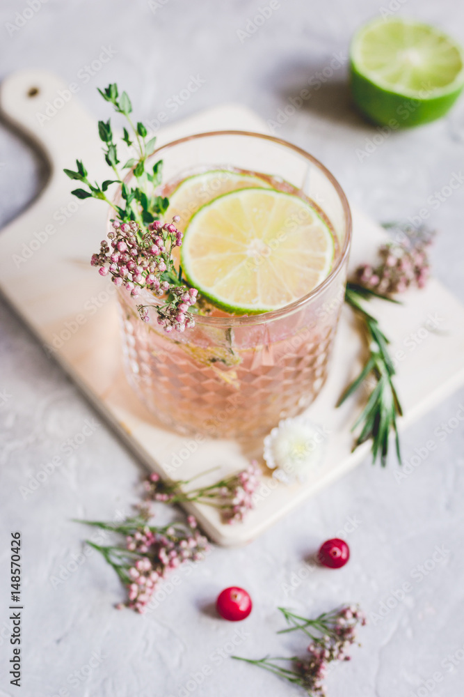 natural cocktail with berry and cut lime on stone desk background