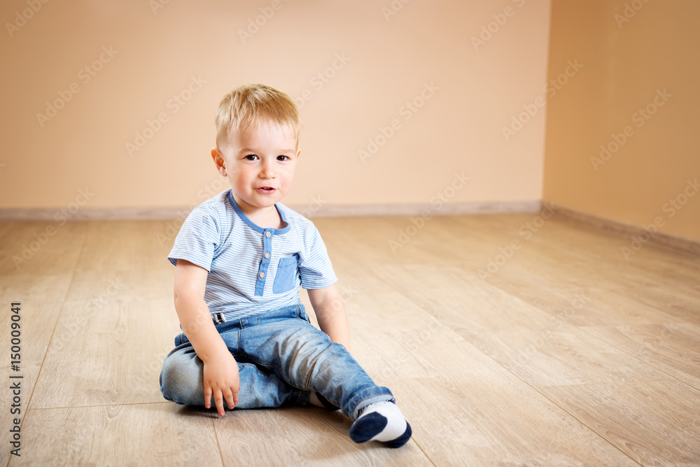 一个两岁的孩子坐在地板上的肖像