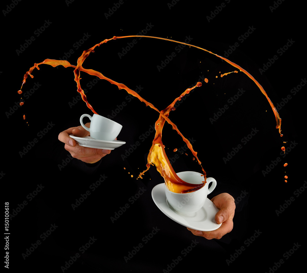 人手拿着瓷杯子，杯子里有飞溅的咖啡或茶液，被隔离在黑色背景上