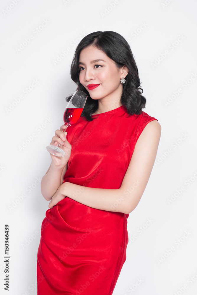 美丽的亚洲女孩穿着晚礼服，拿着一杯香槟微笑
