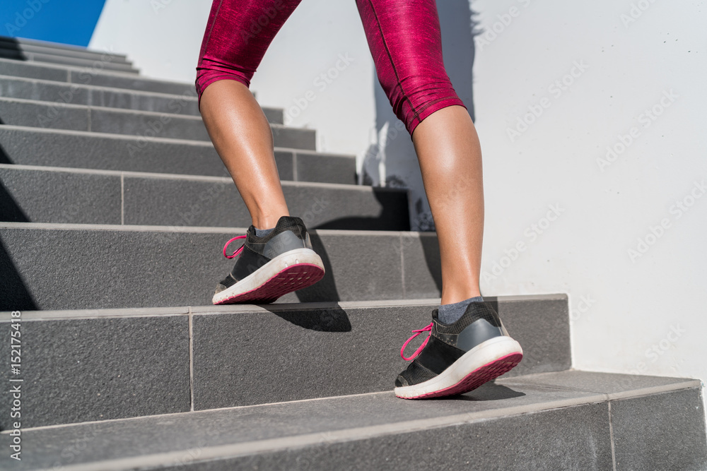 Stairs climbing running woman doing run up steps on staircase. Female runner athlete going up stairs