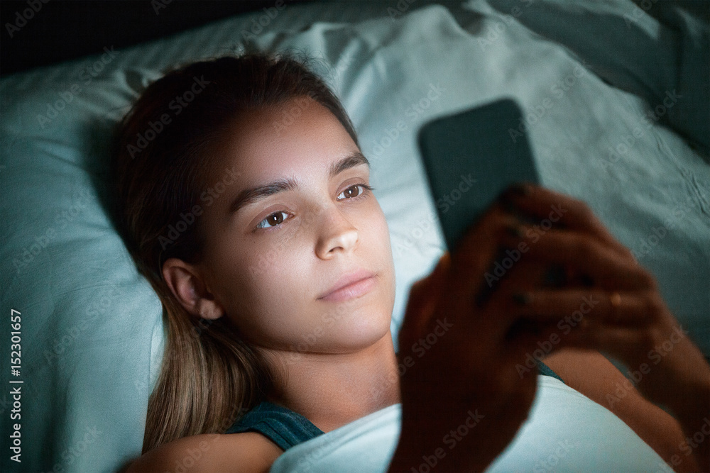 Donna a letto con cellulare, invia messaggi