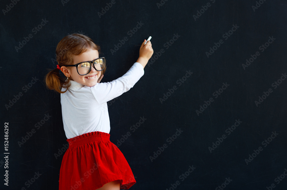快乐的学前班女生靠近学校黑板