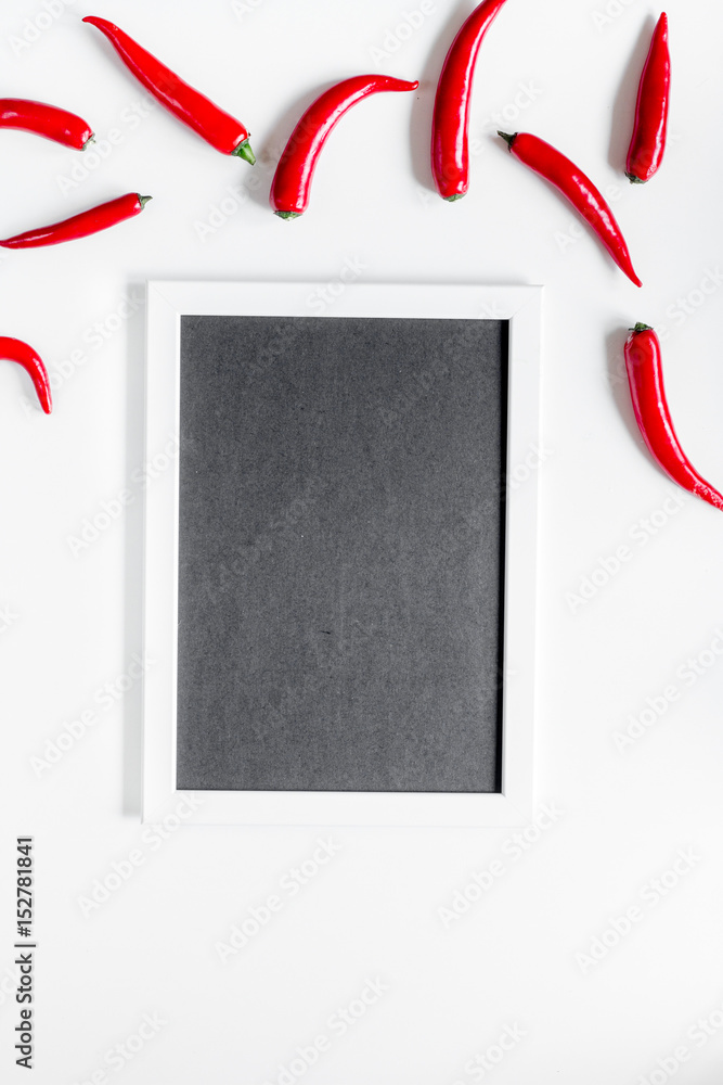 白色桌子背景上的红色辣椒框架的热食物俯视图实物模型