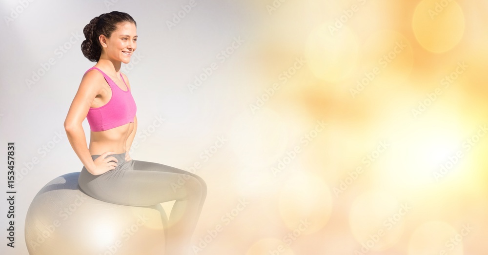 Smiling woman sitting on yoga ball