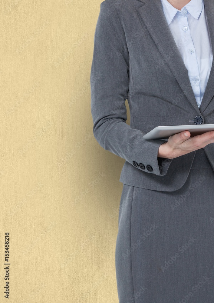 businesswoman holding digital tablet against yellow background